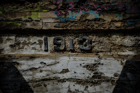 A closeup shot 1913 curved on an old weathered wall