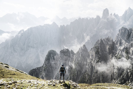 A trekker with a backpack enjoying foggy mountain view