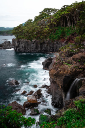A vertical shot of the waves of the sea crashing on the cliffsの写真素材