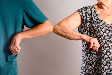 A person waving elbow with his grandmother greeting together by new style to prevent coronavirus - social distancing and the new normal conceptの写真素材