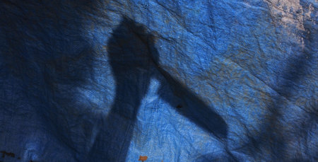 A high angle shot of a shadow of human hand holding a knife- murder conceptの写真素材