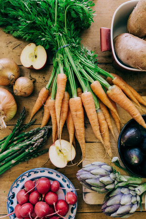A vertical top view of fruits and vegetables on a wooden table