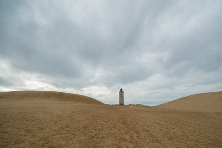 A low angle shot of the Rubjerg Knude Lighthouse in the middle of sand dunes in northern Denmarkの写真素材