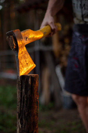 A man holding the  sharp axe in the cut wood on the groundの写真素材