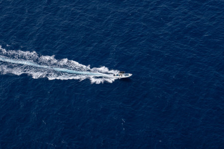 A high angle shot of a motorboat sailing on the surface of the sea