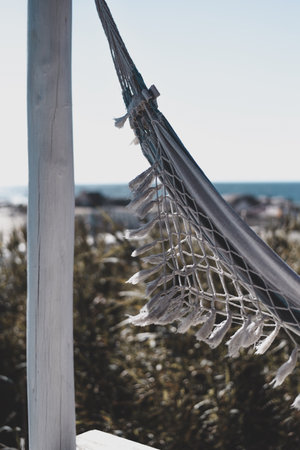 A vertical selective focus shot of white hammock on the beachの写真素材