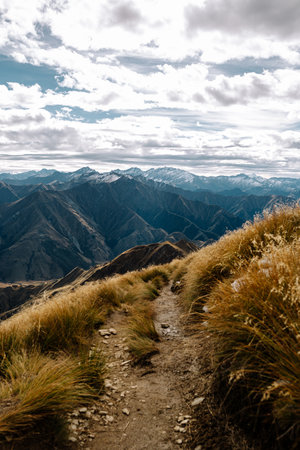 A vertical shot of huge mountains under a cloudy skyの写真素材