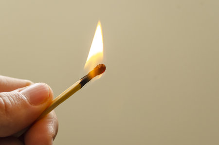 A closeup shot of a person holding a burning matchstickの写真素材