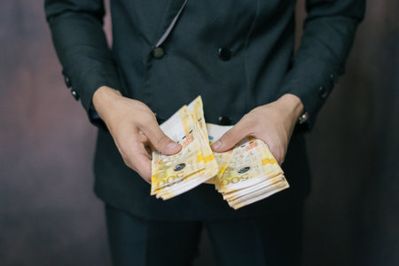 Portrait of a Successful Business Man Counting a lot of Philippine Banknotes Money. Success in Business Finance Economy Currency over Successの写真素材