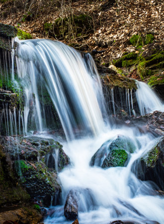 A beautiful waterfalls with mossy rocks in the forest