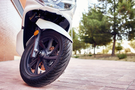 A closeup  of a motorcycle wheel in the foreground