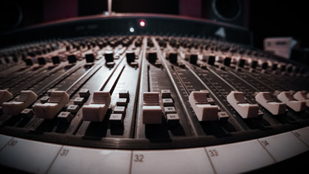 A closeup shot of soundboard buttons and adjusters in studio