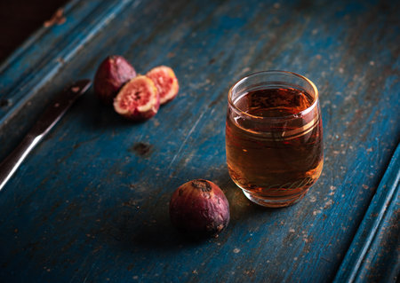 A closeup of glass with juice and figs on the sideの写真素材