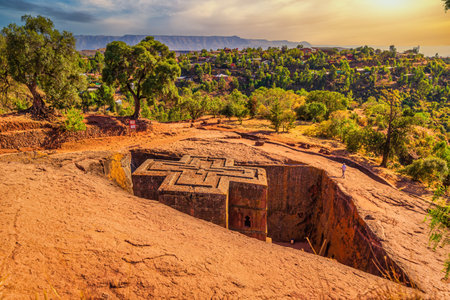 A landscape view of Lalibela, Ethiopia with the cross-shaped roof of Saint George church in frameの写真素材
