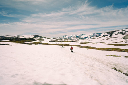 A low angle shot of a man walking on snowy hillsの写真素材