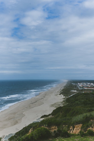 A beautiful aerial view of sandy beach with turquoise water and cloudy sky
