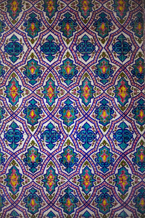 A vertical shot of a ceramic wall texture with painted colorful patterns