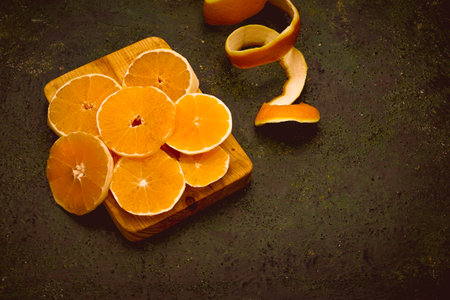 A closeup shot of orange slices with peels on a chopping board