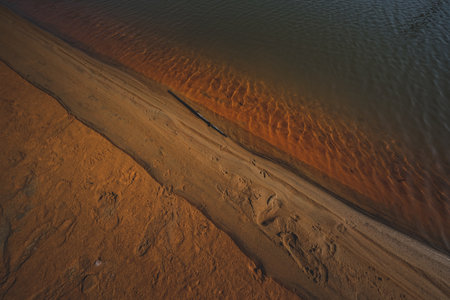 A top view shot of the sand in front of the water on the beachの写真素材
