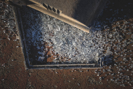 A high angle shot of broken glass pieces on the ground