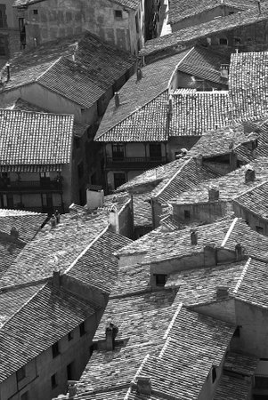 A grayscale shot of rooftops of a small village in Spainの写真素材