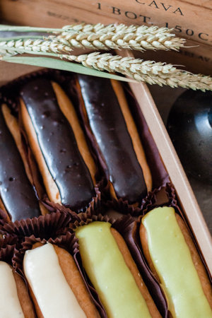 A vertical top view of sweet eclairs with black and white chocolate icings