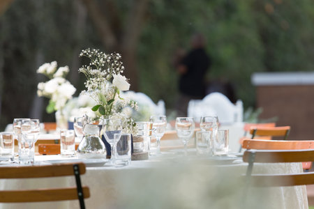 A table with beautiful utensils and centerpieces, for a wedding reception outdoorsの写真素材
