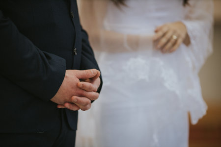A selective focus shot of groom and bride hands during the wedding ceremony