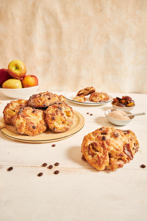 A vertical closeup shot of baked delicious apple curd balls on a table with ingredientsの写真素材