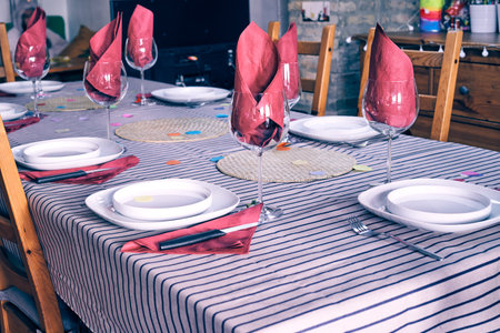 A table with plates, wine glasses and purple napkins - preparation for the party, celebration