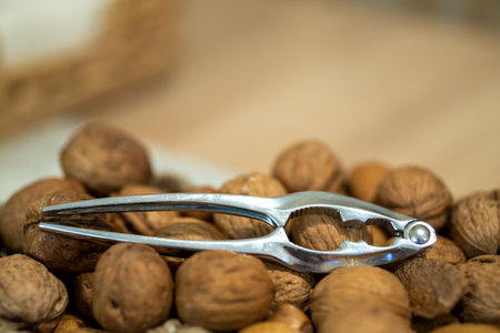 A selective focus shot of a nut cracker on walnuts in a basket