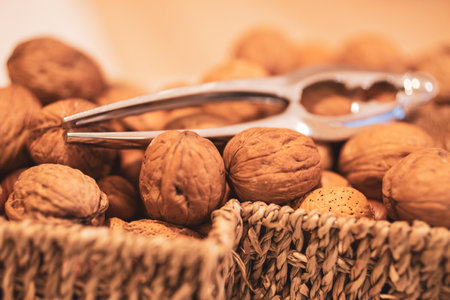 A selective focus shot of a nut cracker on walnuts in a basket