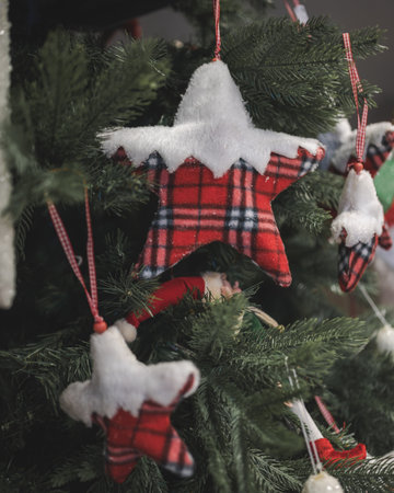 A vertical shot of star ornaments hanging on a Christmas tree