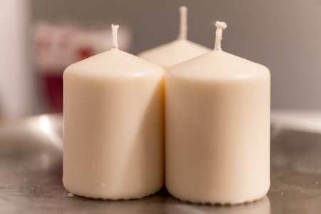 A selective focus shot of three decorative white candleの写真素材