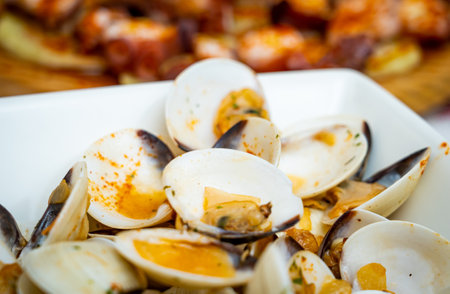 A closeup of a bowl of cooked delicious clam of wine on the table with a blurry background