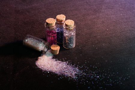 A closeup shot of spilled glitter from a small glass bottleの写真素材