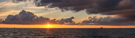 A panoramic shot of a beautiful sunset over a sea