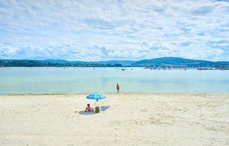 A beautiful shot of a calm beach under a cloudy bright skyの写真素材