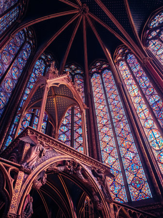 A vertical low angle show of bright colorful stained glass windows in a churchの写真素材
