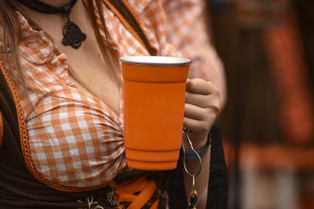 A closeup shot of a female holding a cup of beerの写真素材