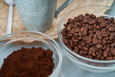 A closeup shot of aromatic coffee beans, melted coffee, cup and spoonの写真素材