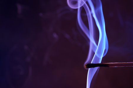 A burning matchstick and a long blue flameの写真素材