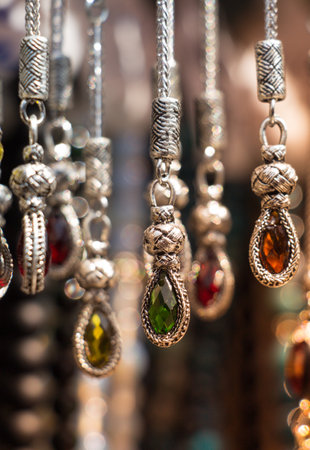 A vertical of hanging necklaces with colorful precious jewelsの写真素材