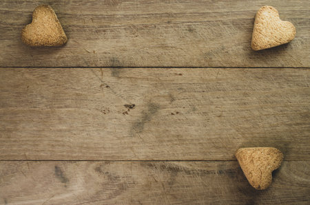 A closeup shot of hearth shaped cookies on wooden backgroundの写真素材