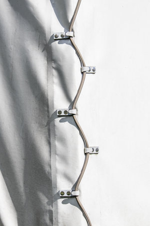 A detailed closeup of a closed tarpaulin by ropes of a trailer