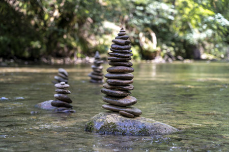 A majestic shot of many stone pyramids balanced on a river waterの写真素材