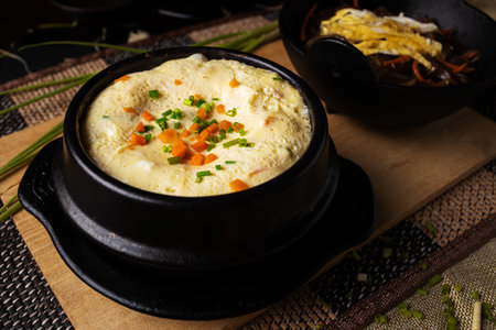 A high angle shot of a bowl of delicious hummus and some vegetables on a wooden tableの写真素材