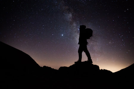 A silhouette of a hiker standing with a milky way behind in Sierra Nevada, Spainの写真素材