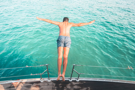 A male jumping into a lakeの写真素材