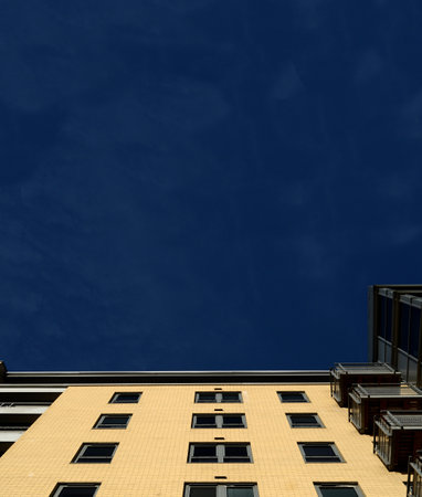 A low angle shot of a residential building under the sunlight and a blue sky